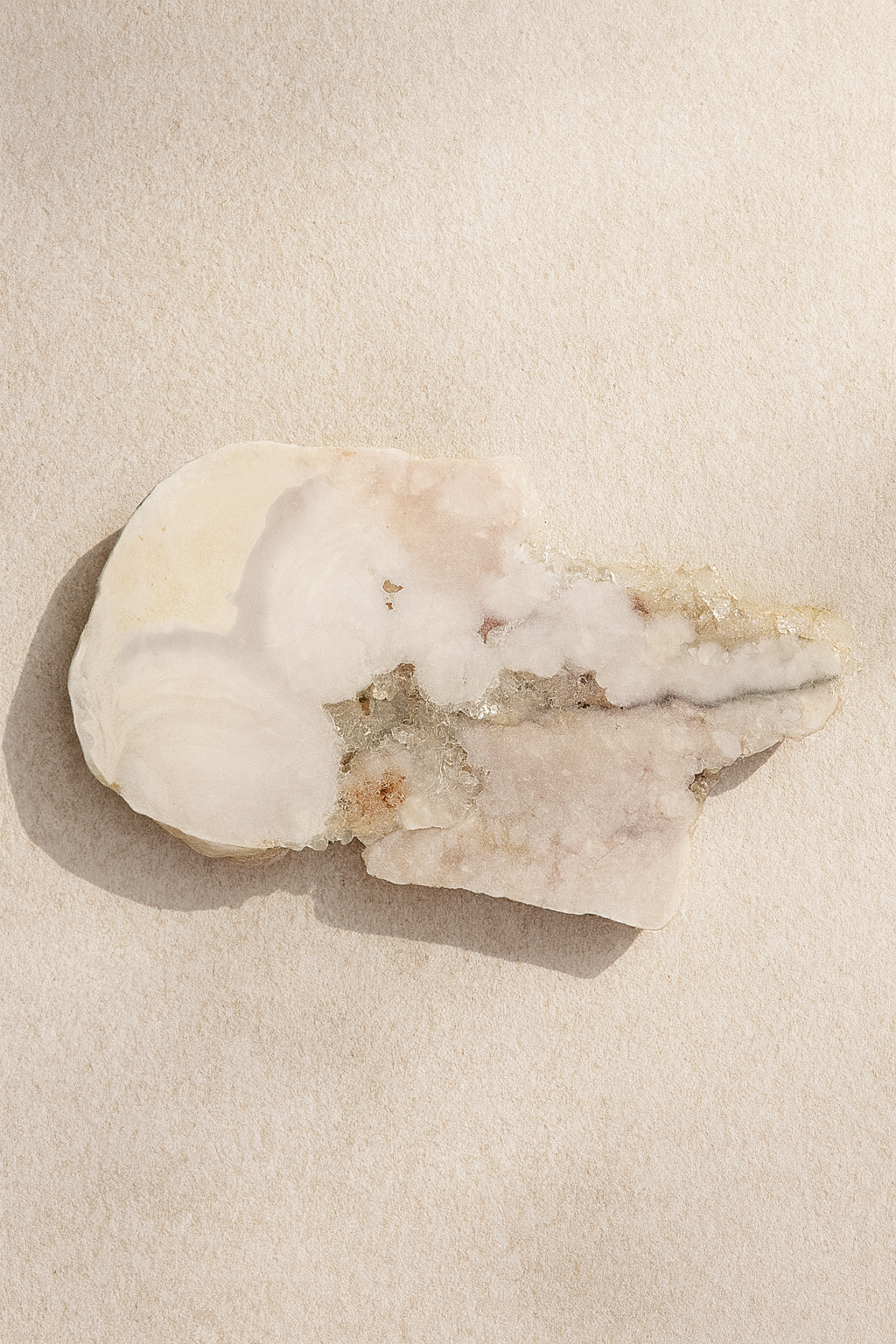 “Polished Pink Amethyst slab from Brazil, approx. 8x5 inches, displayed on a neutral stone surface with soft beige plaster background — luxury natural decor by Luxe Natural Decor.”